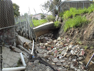 Photo shows Peralta Creek before. Shows deteriorating concrete flood channels, debris and trash accumulation.